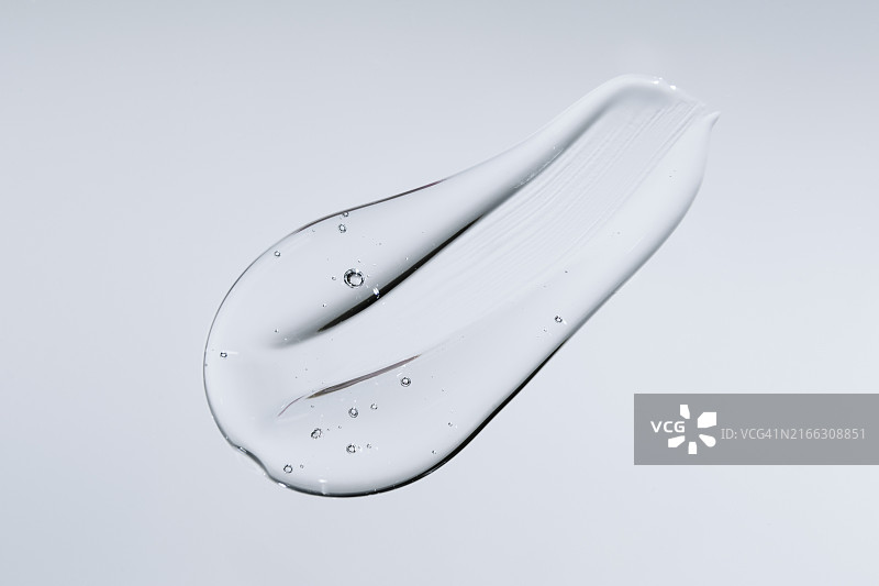 灰色背景上的透明涂抹液体凝胶图片素材