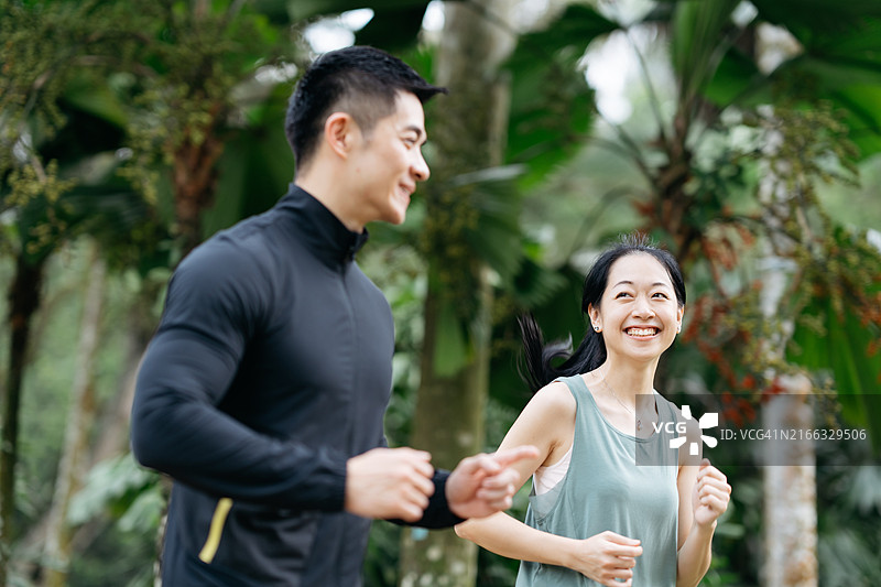 亚洲情侣穿着运动服在公园晨跑图片素材