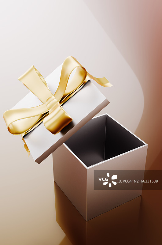 米色背景下带有礼物和金色蝴蝶结的敞开盒子的特写图片素材