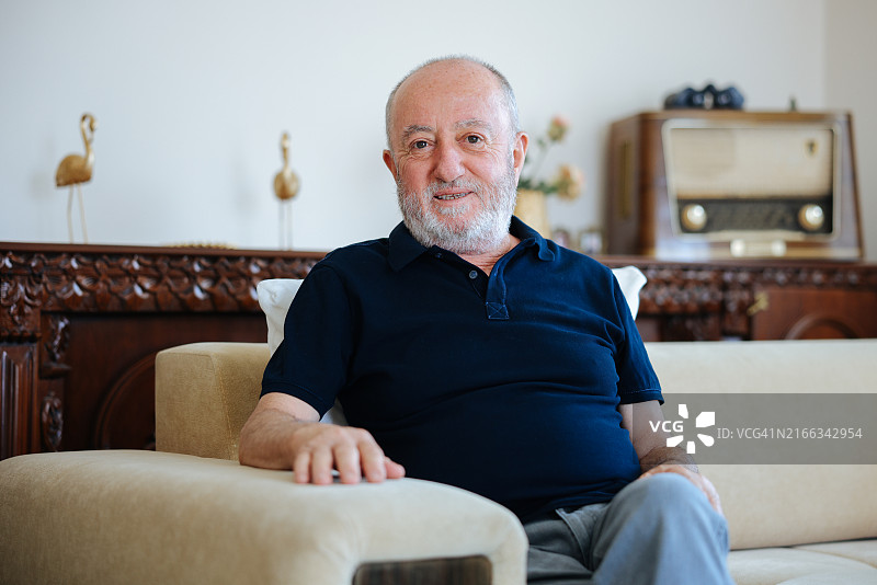 坐在客厅沙发上微笑的中年男人图片素材