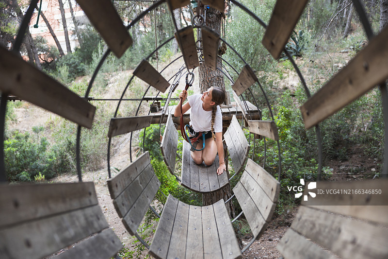 年轻女子在户外探险公园享受滑索图片素材