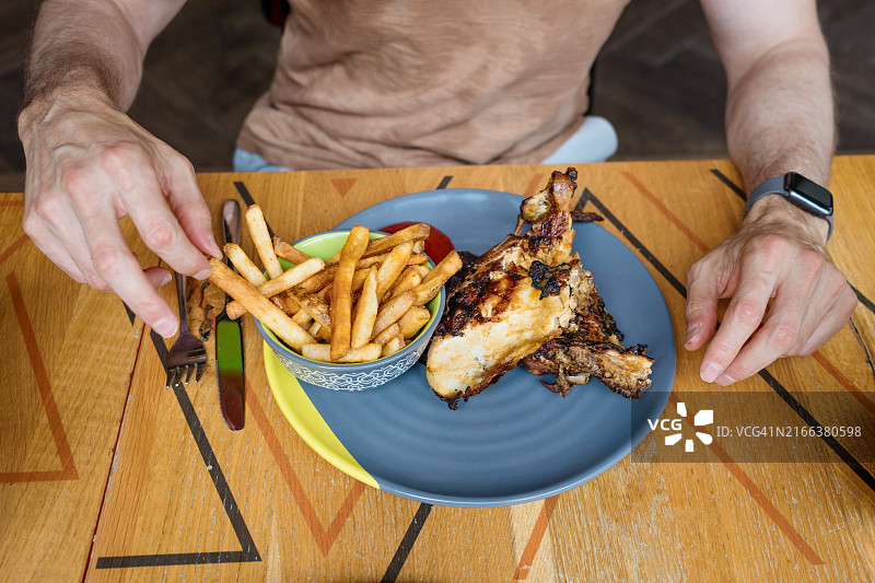男人在餐厅吃炸鸡和薯条图片素材