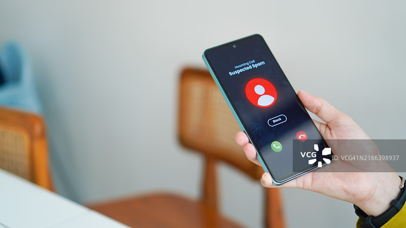 戴着盖头的女人收到来自智能手机上未知来电者的可疑来电并拒绝了该来电图片素材