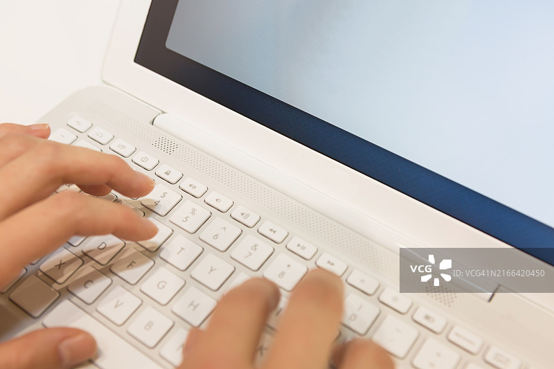 使用键盘和白色笔记本电脑的双手图片素材