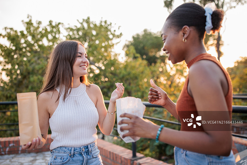 两个年轻朋友在公园里吃爆米花图片素材