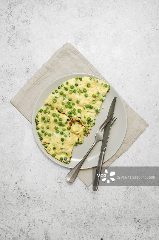 灰色石板桌面盘子里的鲜青豆奶酪煎蛋卷图片素材