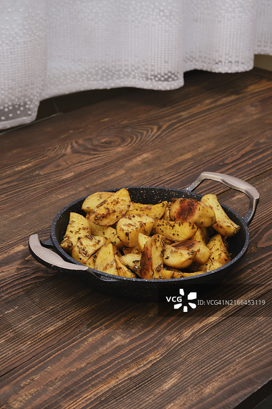 烤盘中的烤土豆角配香料、香草和大蒜图片素材