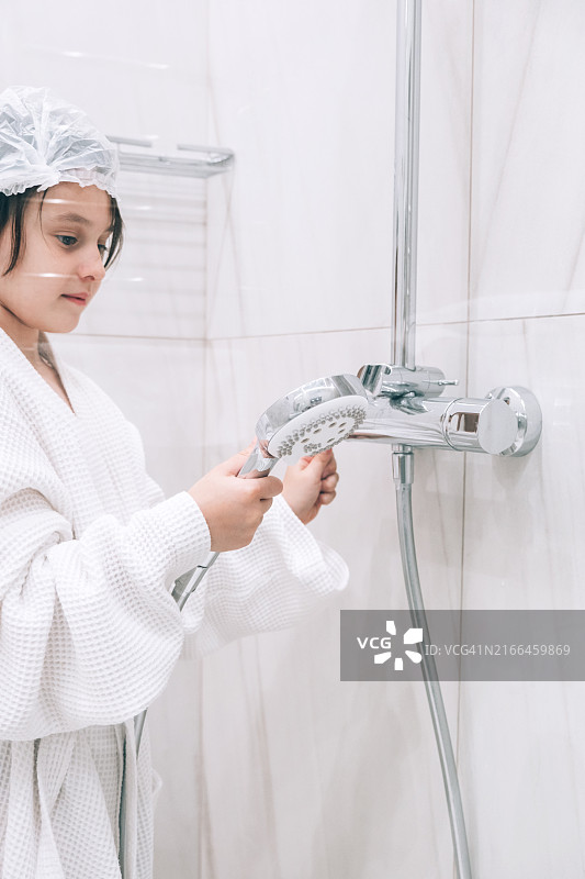 在浴室里戴着浴帽准备洗澡的女孩图片素材