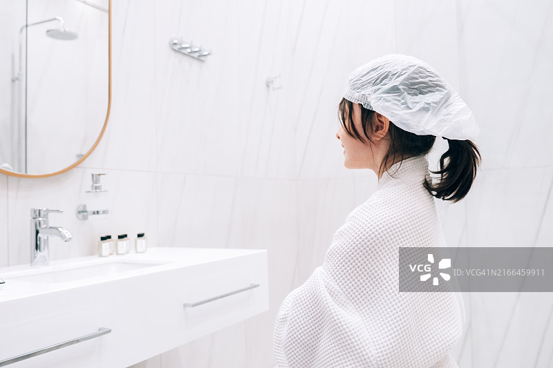在浴室里戴着浴帽准备洗澡的女孩图片素材