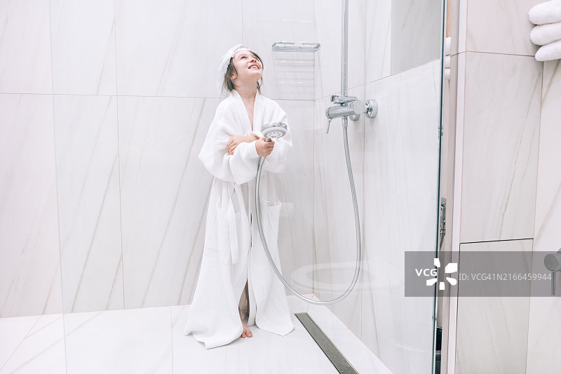 在浴室里戴着浴帽准备洗澡的女孩图片素材