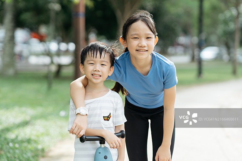 在公园里玩滑板车的儿童肖像图片素材