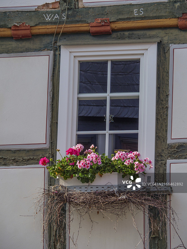 德国黑森州瓦尔德克，老房子的窗户，带有装满粉色鲜花的窗台花箱和乡村装饰图片素材