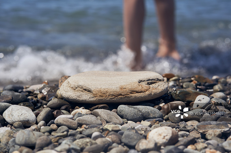 带有模糊腿部的海边产品展示。您的设计样机图片素材