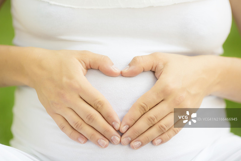 孕妇双手在腹部摆出心形图片素材