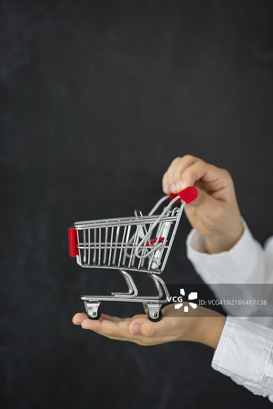手持购物车，黑色背景图片素材