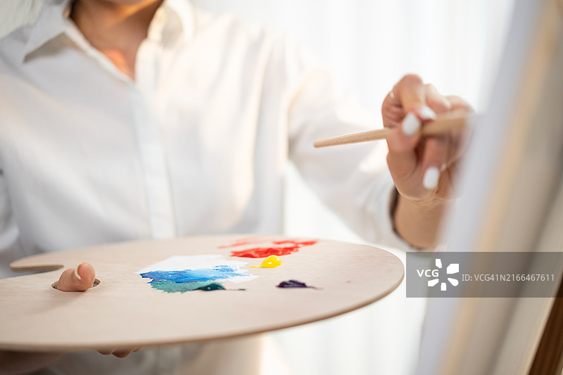 年轻女艺术家在艺术工作室绘画图片素材