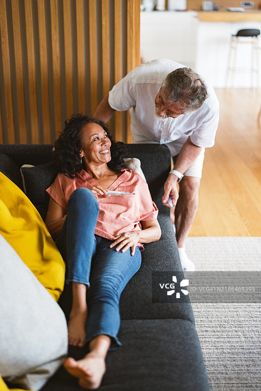 在家使用医疗设备的老年西班牙裔女性和白人男性图片素材