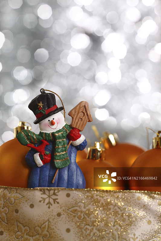 银色背景上的雪人和金色球图片素材