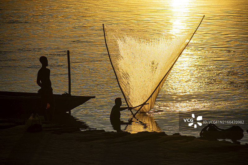 2023年8月1日,在印度阿萨姆邦古瓦哈提,于布拉马普特拉河日落时分捕鱼的渔民图片素材