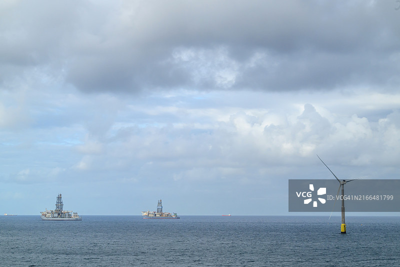 石油钻井船附近的离岸风车图片素材