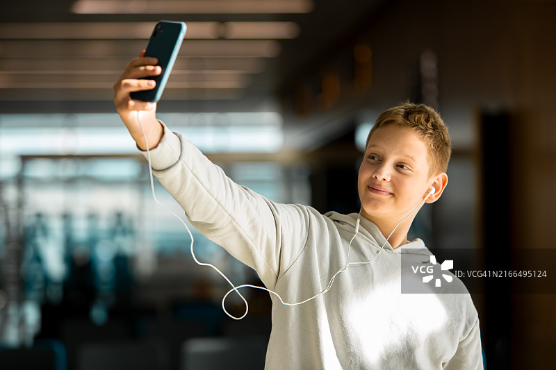 在机场休息室微笑自拍的青少年男学生图片素材