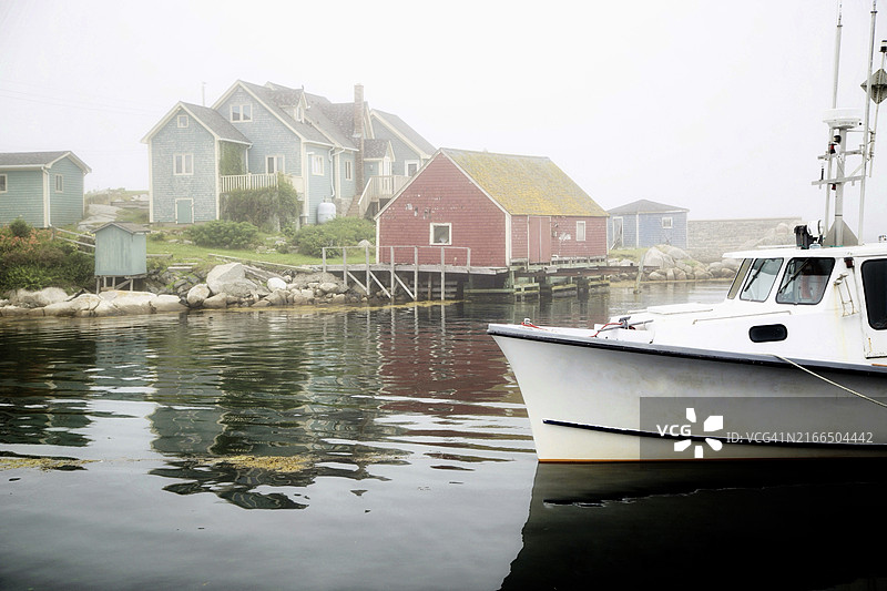 系泊船和海滨建筑的雾蒙蒙的海港景色图片素材