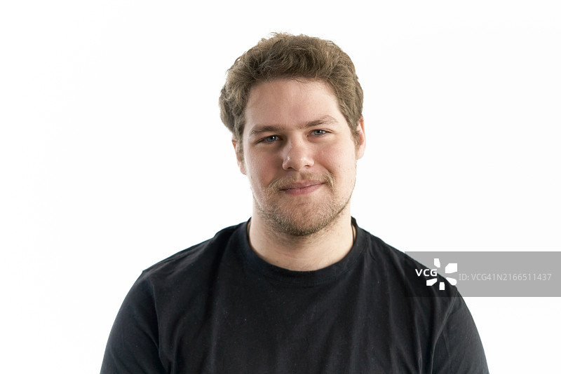 穿着黑色T恤，面带微笑看向镜头的年轻蓝眼睛金发女子图片素材