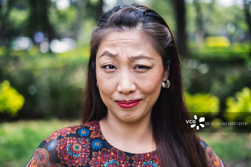 扬起眉毛看向镜头的亚洲女性，神情疑惑图片素材