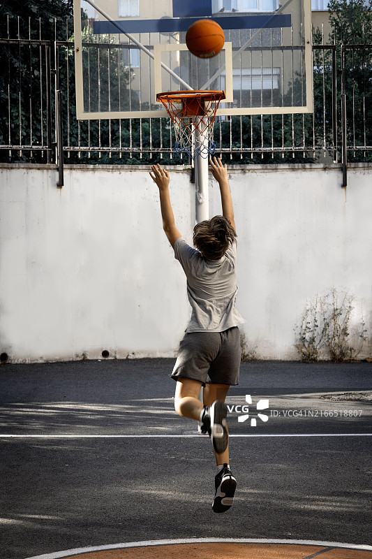 年轻男孩在花园里打篮球图片素材