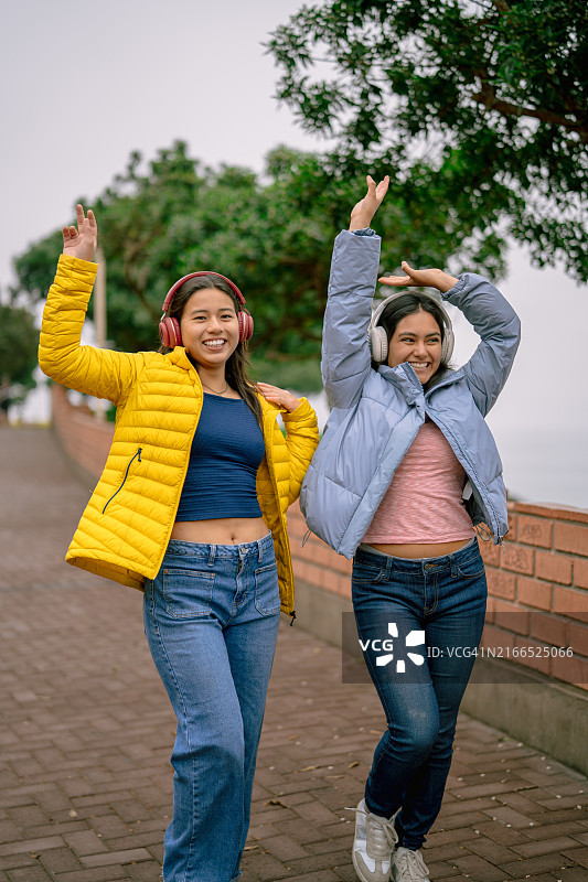 女人们在木板路上快乐地听着音乐跳舞图片素材