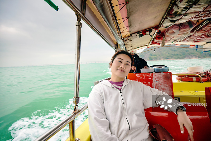 坐在渔船上体验当地风情的女游客图片素材
