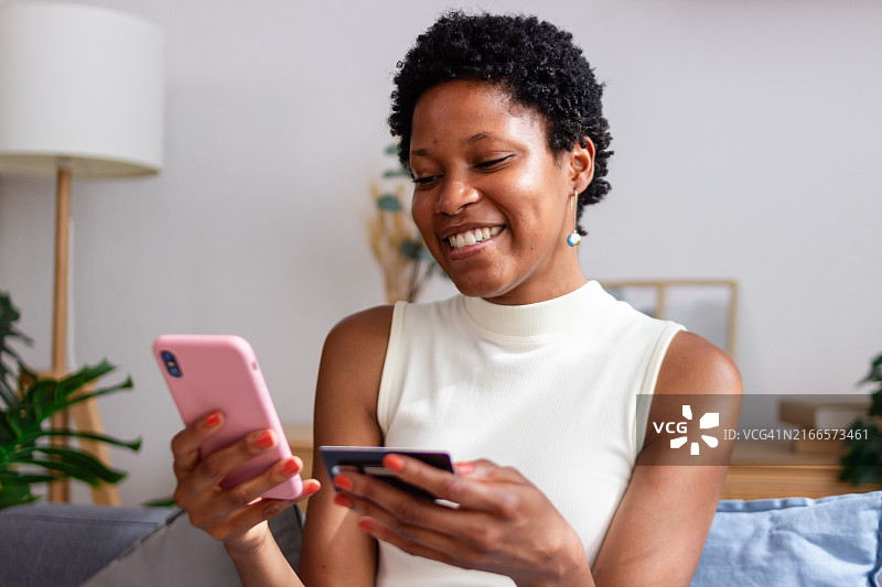 快乐的客户使用信用卡和智能手机进行在线支付图片素材