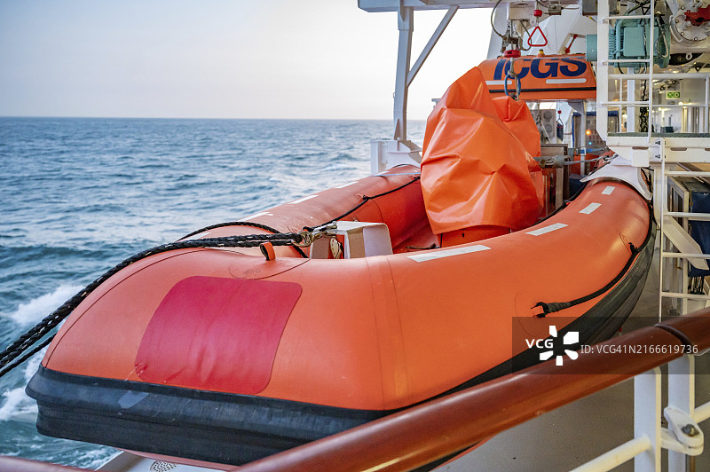 夕阳下，橙色的爱达贝拉号游轮救生艇图片素材