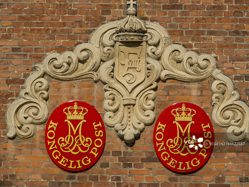 丹麦埃斯比约的砖砌建筑上的皇家邮政徽章图片素材