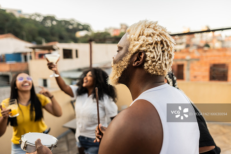 中年男人在屋顶派对上演奏手鼓图片素材