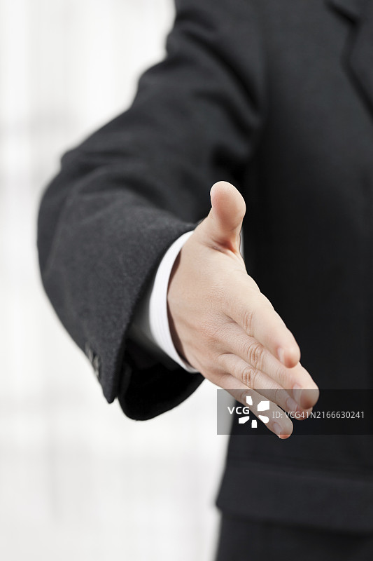 身穿黑色西装的商人做手势问候或握手图片素材