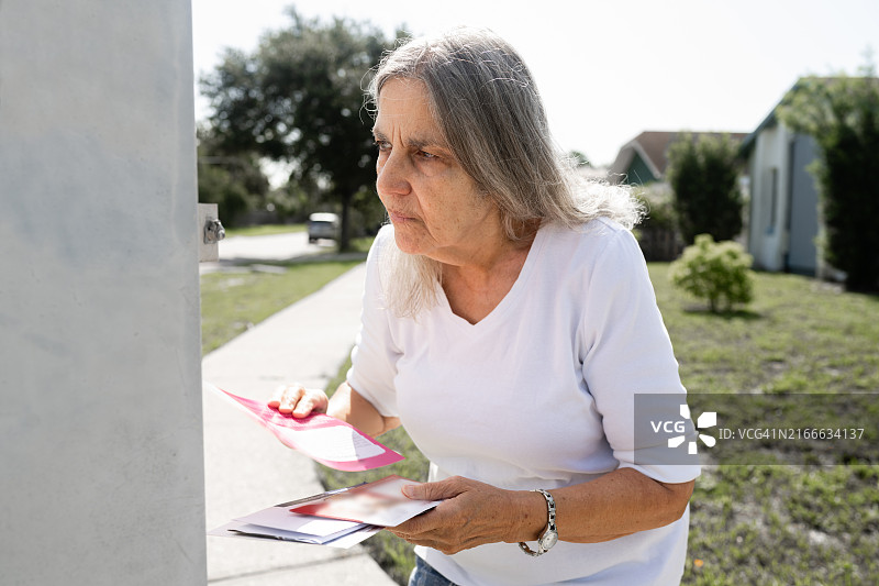 在佛罗里达州郊区收邮件的年长的西班牙裔妇女图片素材
