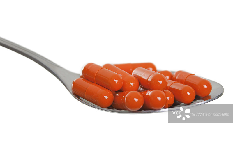 药勺中的医药保健维生素胶囊药丸图片素材