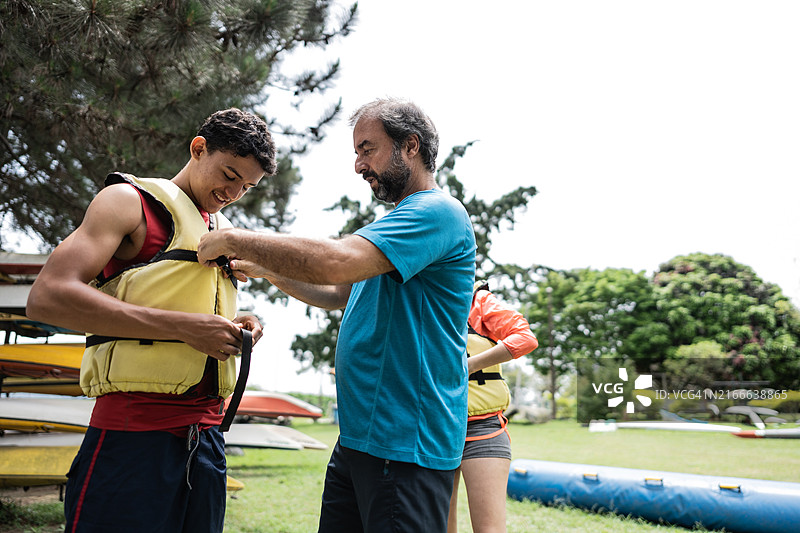 一家人穿好救生衣准备划独木舟图片素材
