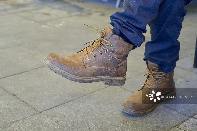 人行道上棕色皮靴特写图片素材