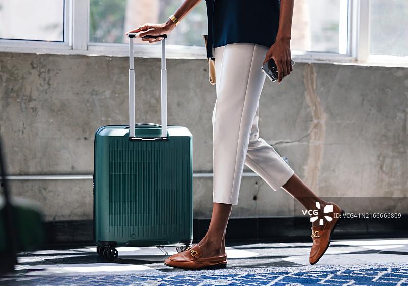 在城市环境中拉着行李箱的商务女人图片素材