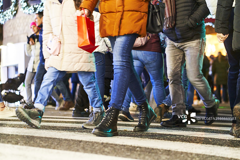 夜间人行横道上行走的人的腿部侧面图片素材