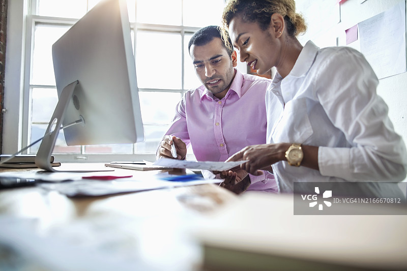 亚裔印度中年男人在现代设计办公室与多人种团队一起工作图片素材