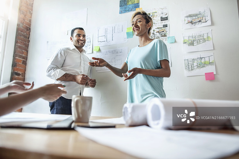 亚裔印度裔黑人尼日利亚多种族中年妇女在设计工作室的商务会议中与同事讨论设计图纸图片素材