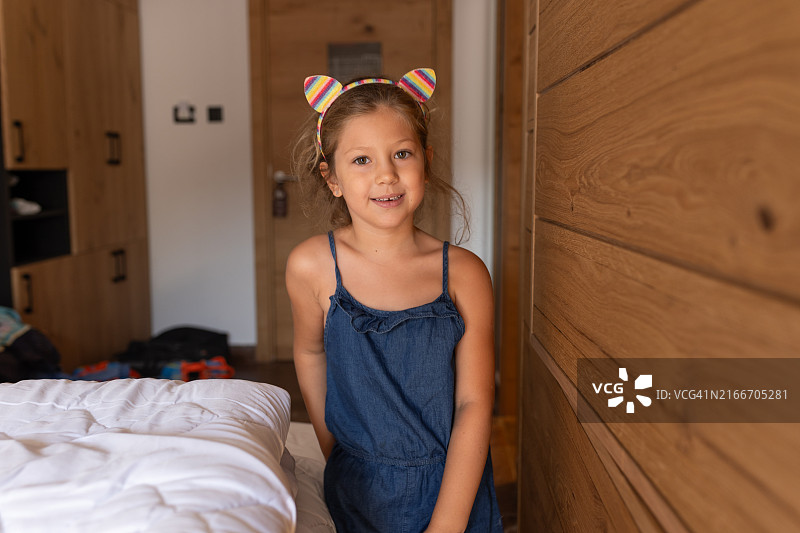 穿蓝色连衣裙的可爱女孩室内肖像图片素材