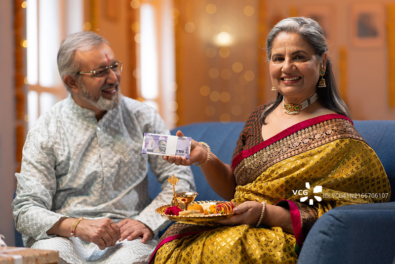姐姐在拉 रक्षा बंधन节给弟弟点吉祥痣并给钱股票照片图片素材