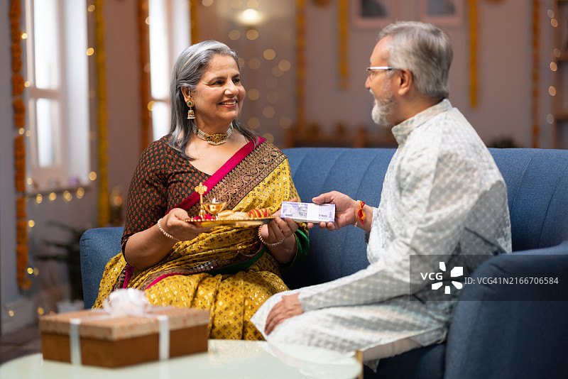 姐姐在拉 रक्षा बंधन节给弟弟点吉祥痣并给钱股票照片图片素材