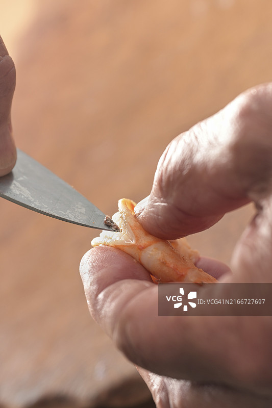 手持刀去除虾线，准备烹饪海鲜图片素材