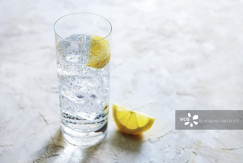 饮用玻璃杯中含冰块和柠檬片的新鲜碳酸矿泉水图片素材