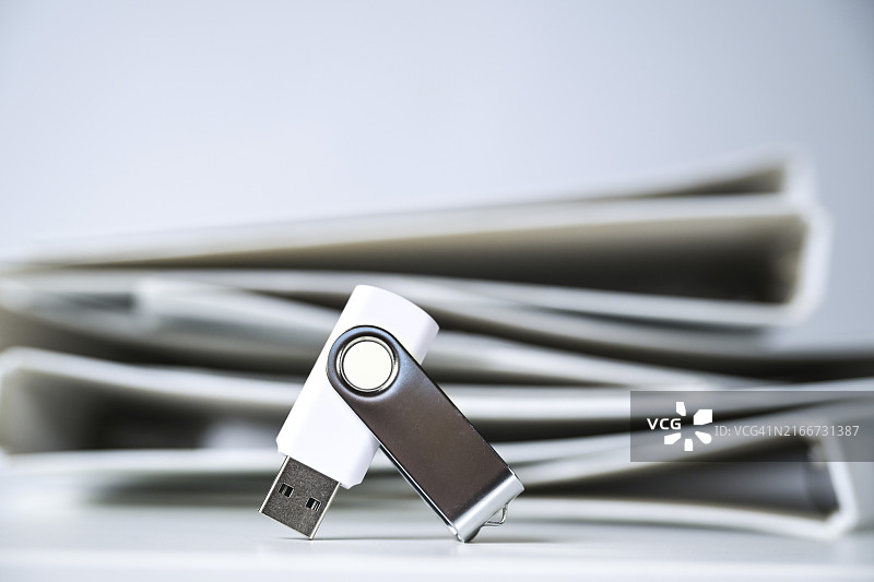 USB闪存盘与白色文件夹，数字化办公概念图片素材